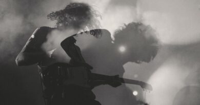A black-and-white shot of a man playing electric guitar in double exposure