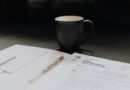 coffee mug near open folder with tax withholding paper